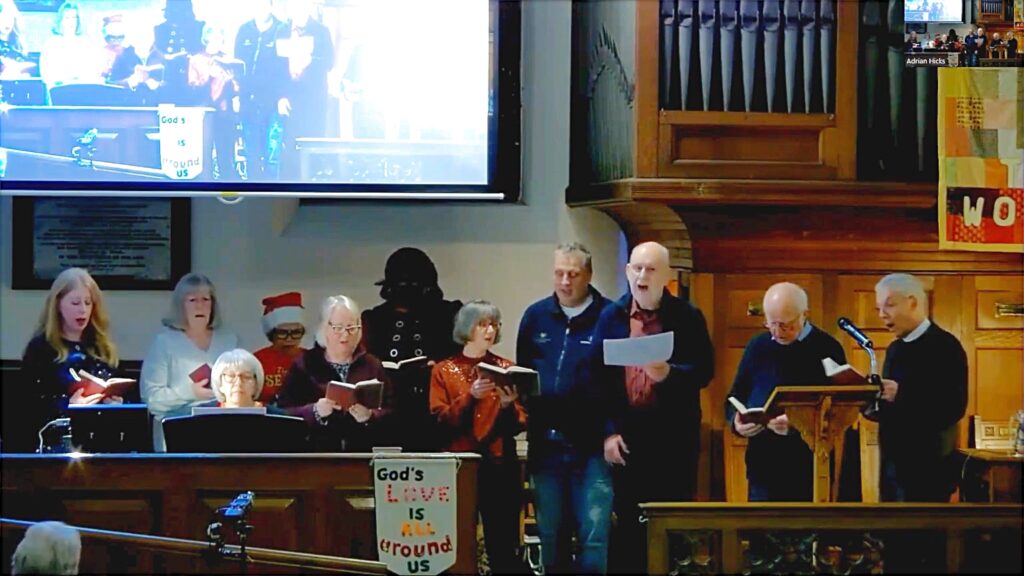 Singing Group singing around the piano in the sanctuary.